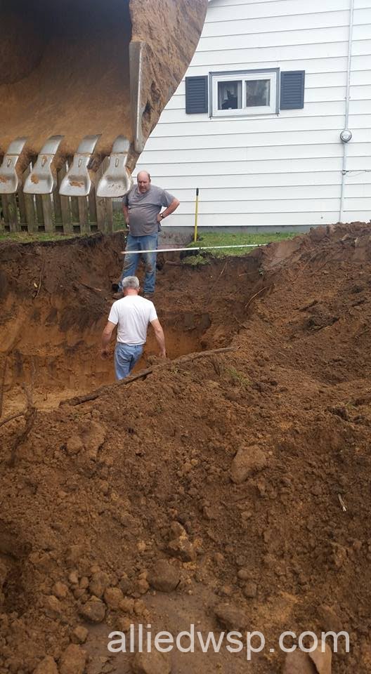 inspecting septic system tank hole in